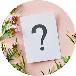 Una nota sobre una mesa rosada con plantas muestra un símbolo de interrogación